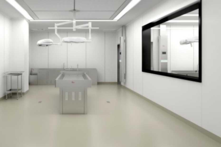 A forensic pathologist in protective gear documenting evidence during a medico-legal autopsy.